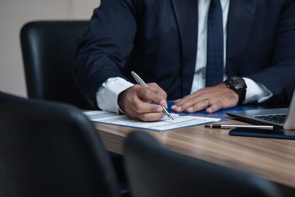 Lawyer at conference table, signing a document